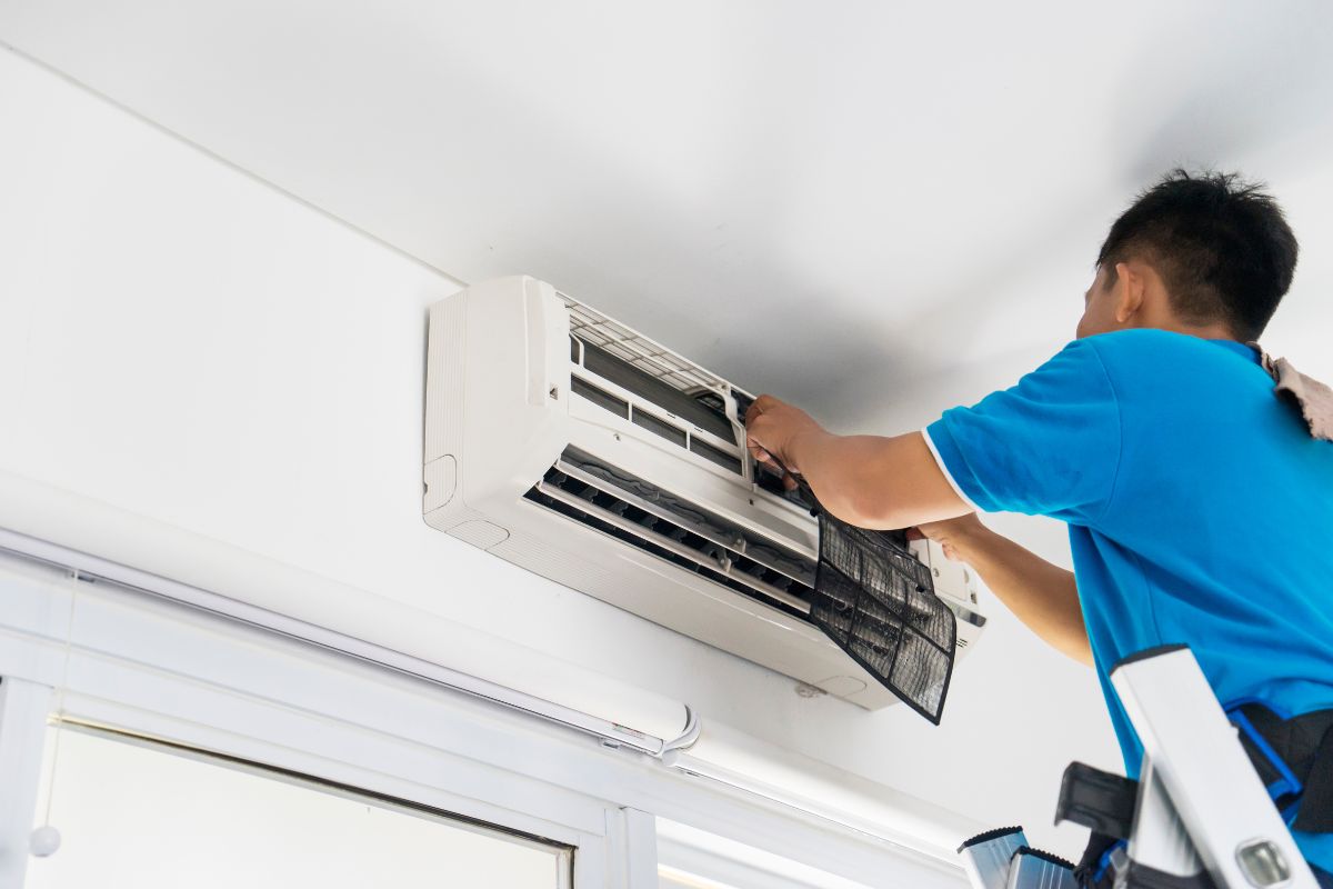 laki-laki membersihkan ac