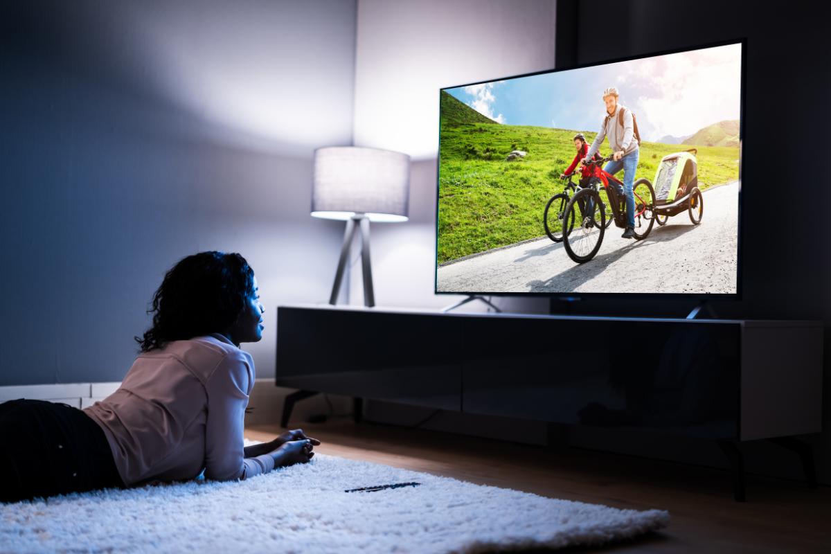 perempuan menonton tv digital di ruang tamu